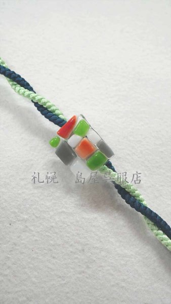 細めの丸紐を通してねじっています